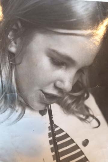 Close up of Maria's face as a young girl, black and white photo, pencil in her hand