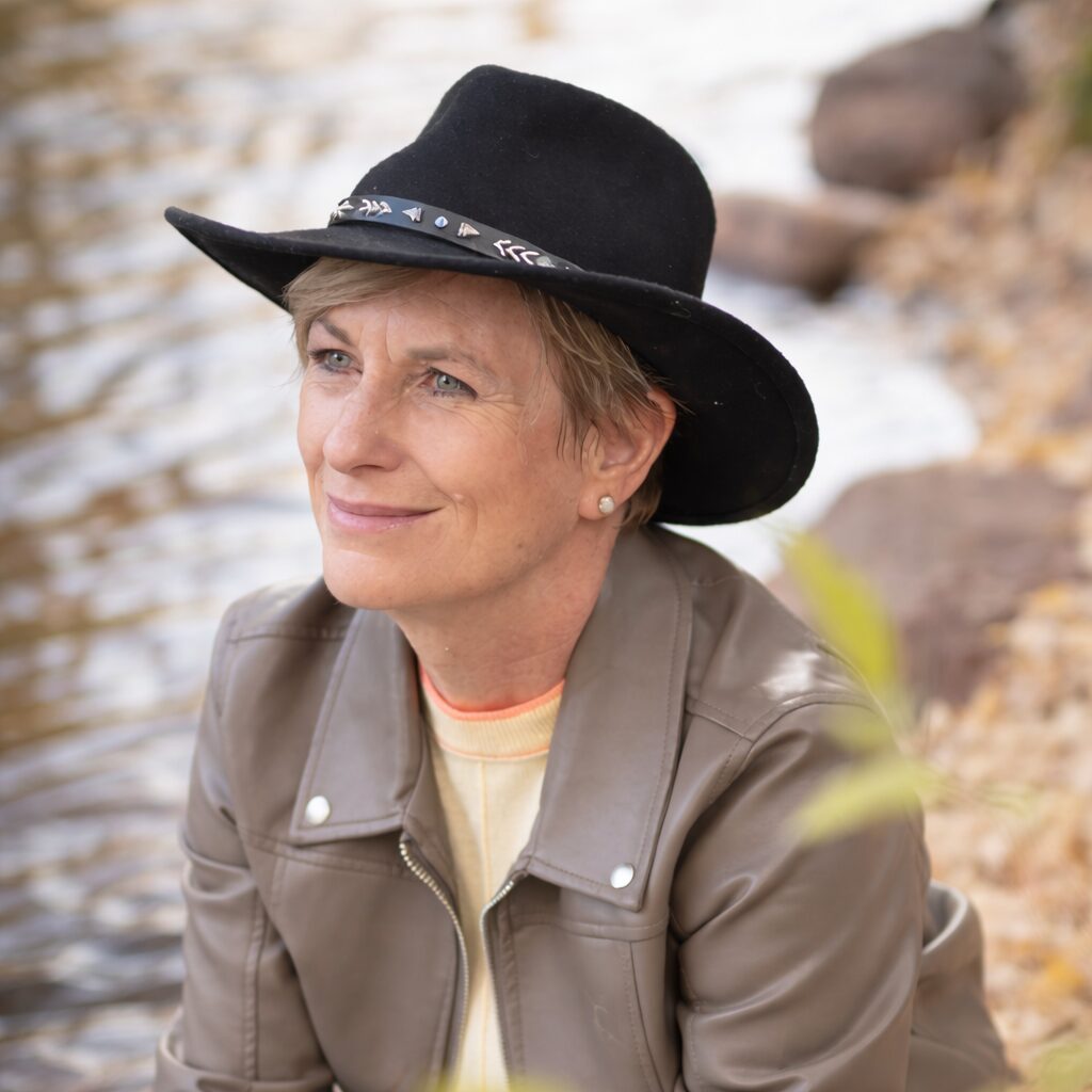 Maria Armstrong with river in background and black cowboy hat