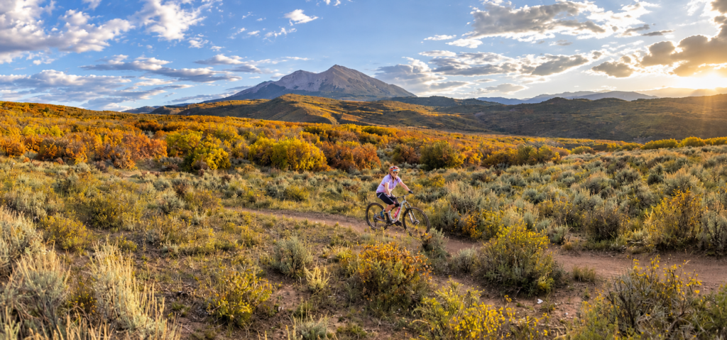 Prince Creek in the Fall, Mt. Sopris in background, Maria on her bike riding across foreground